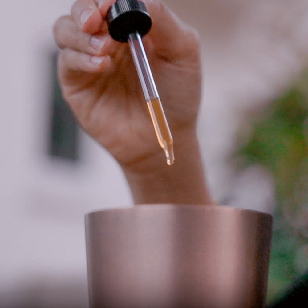 Bartender adding Altar Native herbal drops to a shaker tin